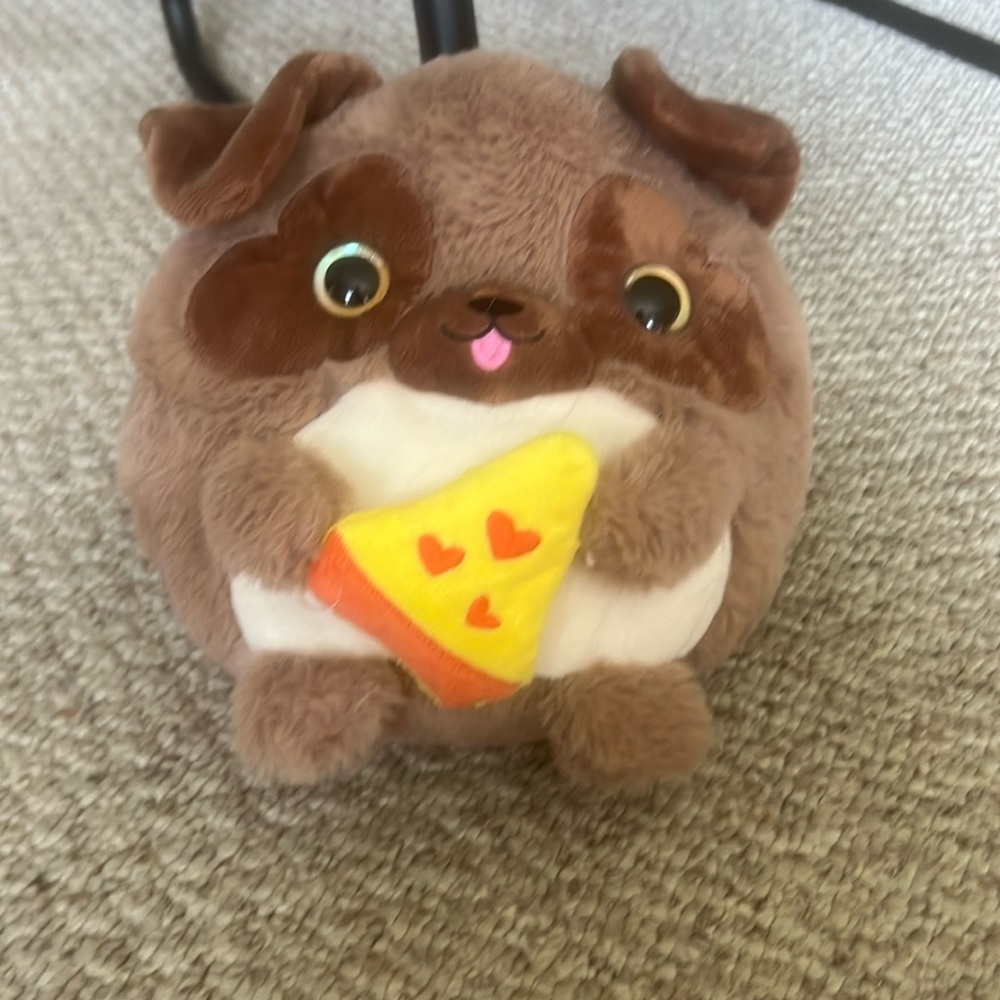 circular brown dog with heart shaped eyes and holding pizza plush